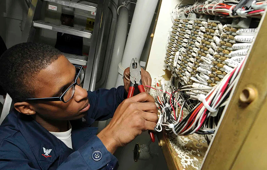 Young engineer handling wiring in a cabinet